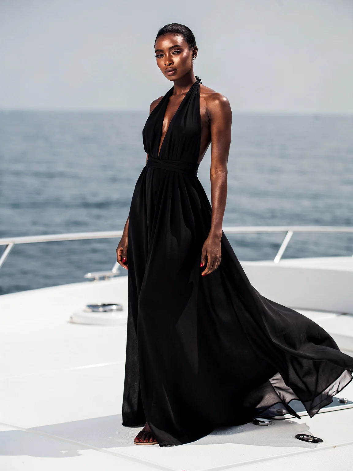 A woman in a black halter gown on a white yacht
