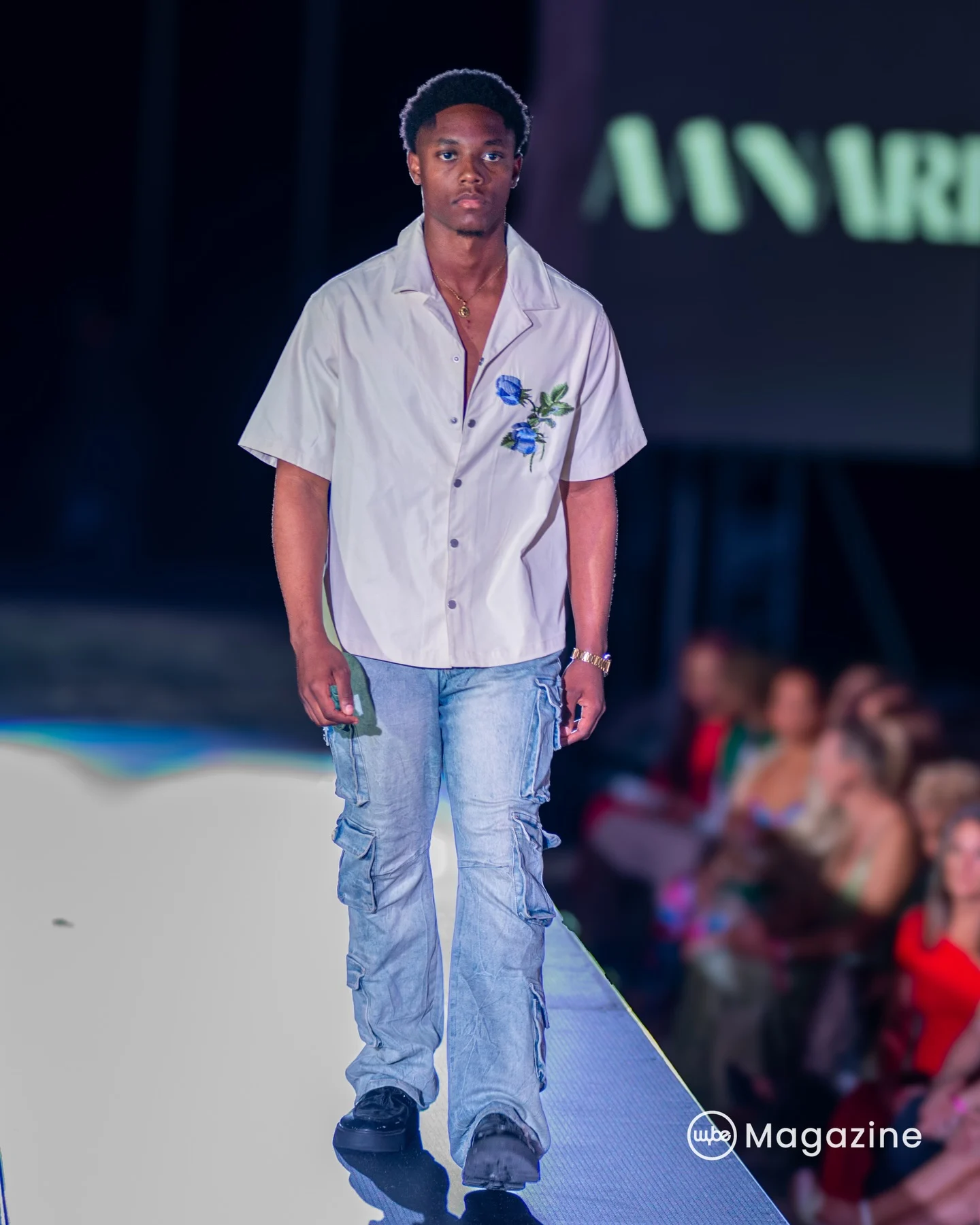 Embroidered blue-rose shirt: A cream camp-collar shirt with embroidered blue roses, paired with light-wash cargo denim.